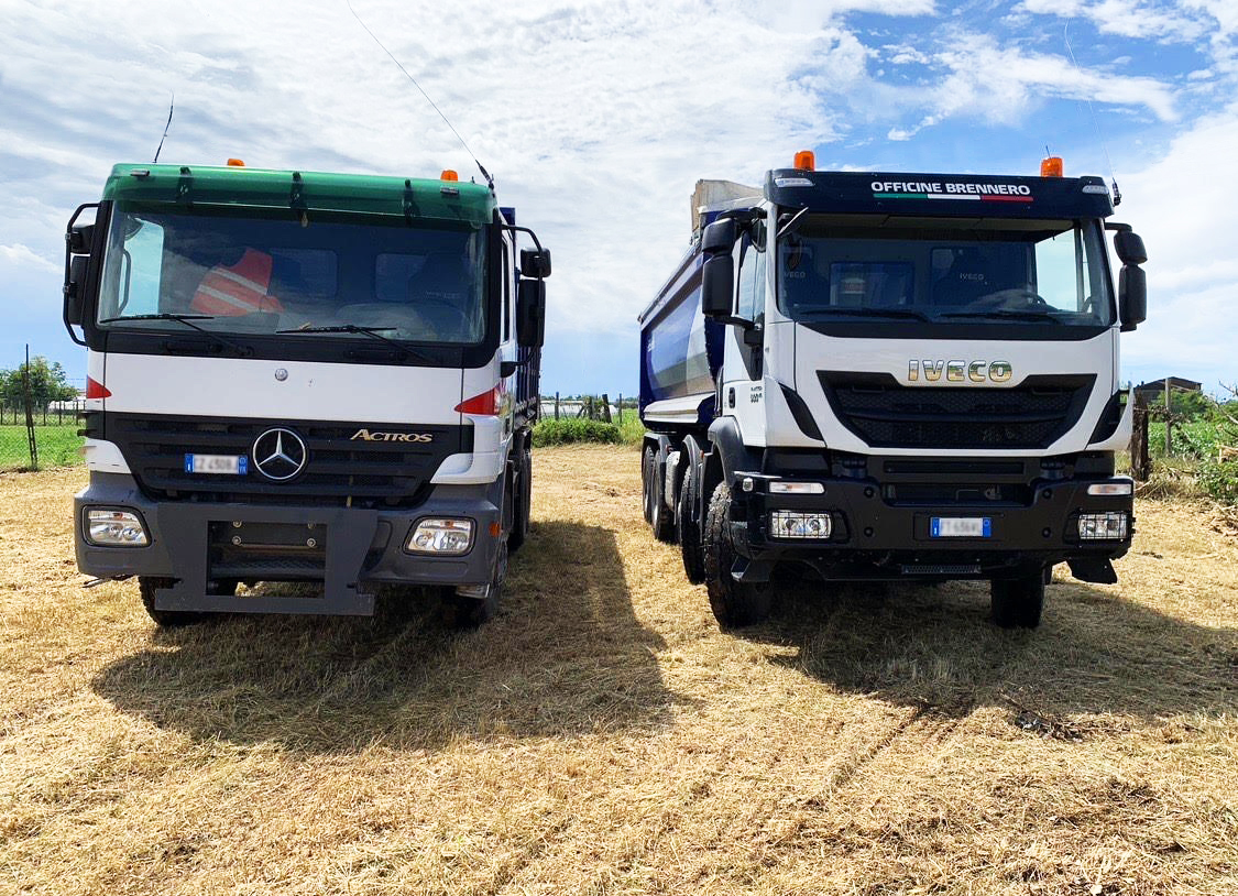 Due autocarri Mercedes e Iveco su prato con dietro cielo azzurro con nuvole bianche in una giornata di sole
